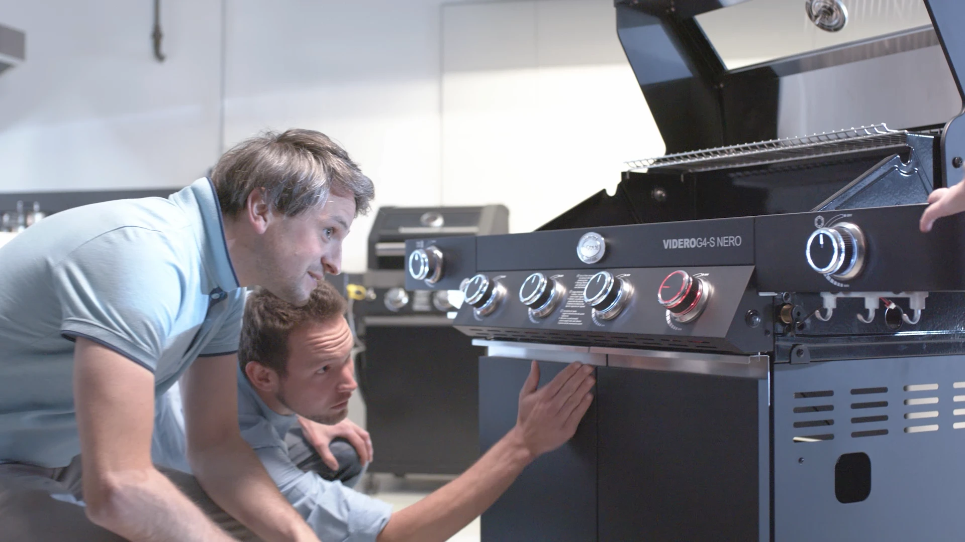 Zwei Männer inspizieren einen modernen Grill im Showroom, produziert von Bürobewegt – visuelles Marketing, 3D, Motion Design.