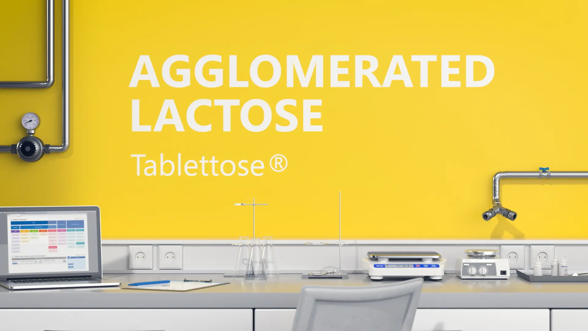 Labortisch mit Laptop und Laborausrüstung vor gelber Wand mit Aufschrift Agglomerated Lactose Tablettose®.