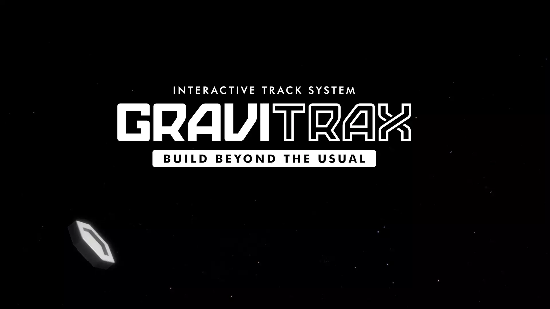 Das GraviTrax Logo in weiß auf schwarzem Hintergrund, ein einzelner weißer GraviTrax Kurvenstein schwebt darunter vorbei