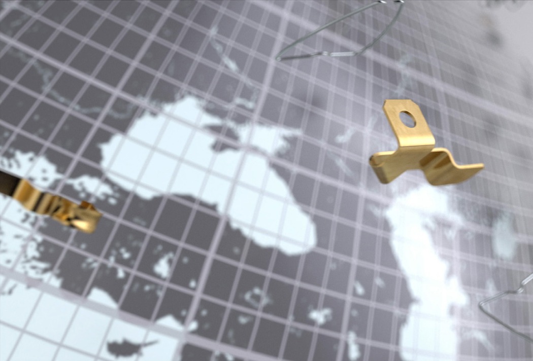 Goldene Metallklammern vor Weltkarte mit Gittermuster im Hintergrund.