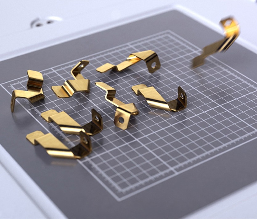 Goldplattierte Metallclips auf einem karierten Schneideuntergrund. Ideal für Konstruktionen und Befestigungen.