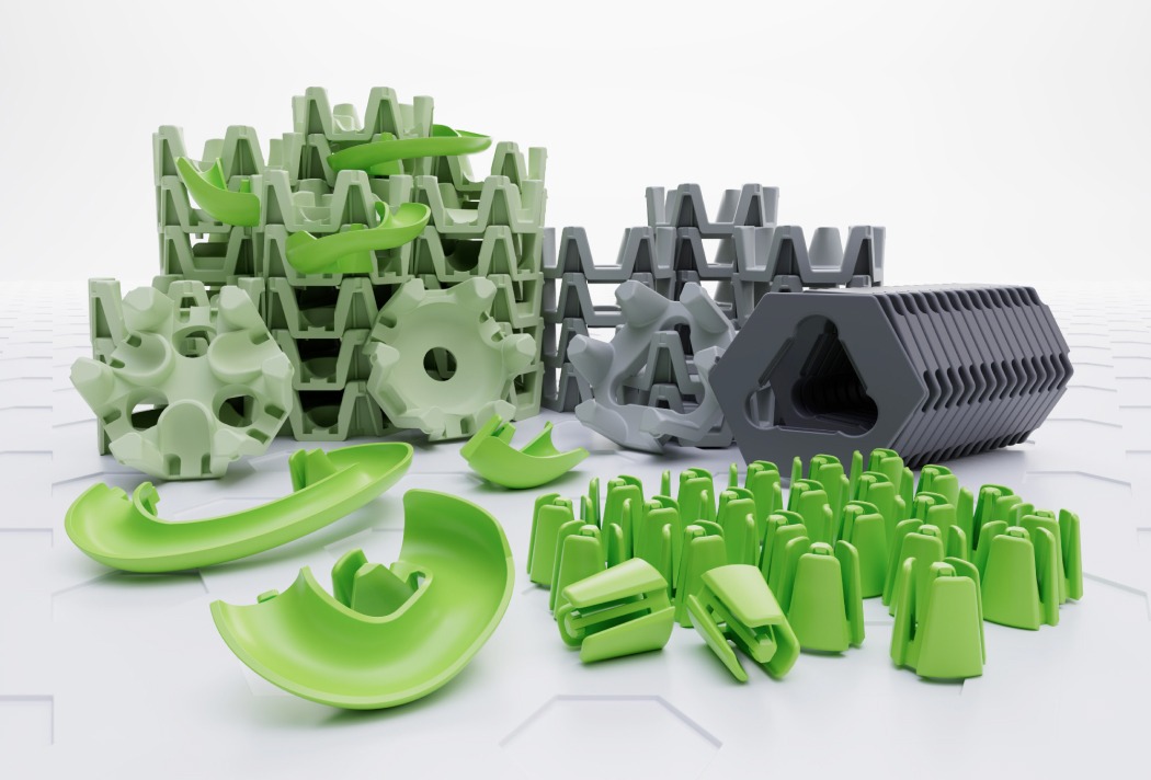 Verschiedene grüne und graue Kunststoffteile in stapelartigen Strukturen auf weißem Hintergrund.