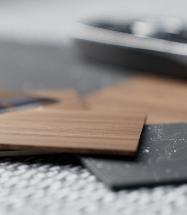 Holz- und Metalltexturen des HYMER B-MC im Designstudio auf einem Tisch arrangiert.