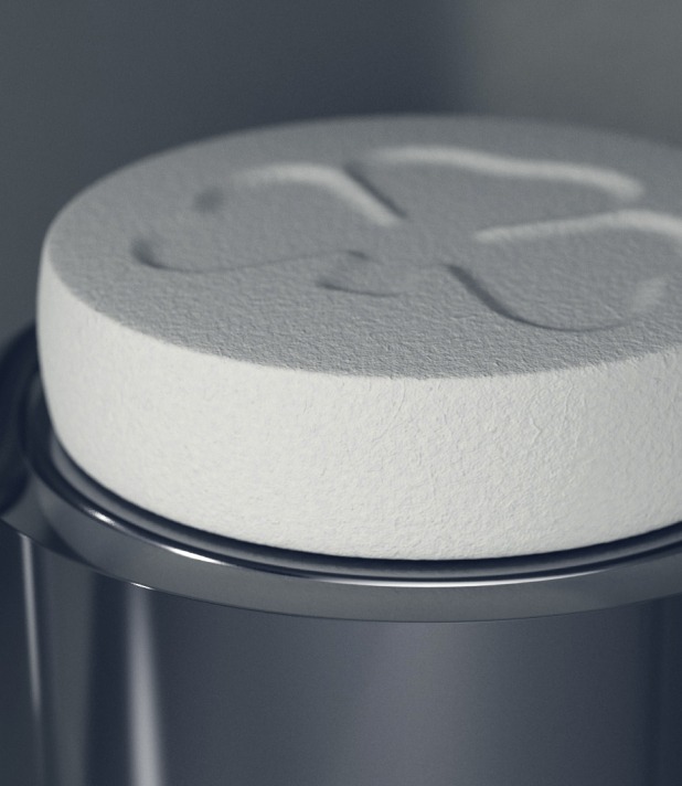 Große weiße Tablette auf Metallbehälter mit eingraviertem Symbol, Nahaufnahme.