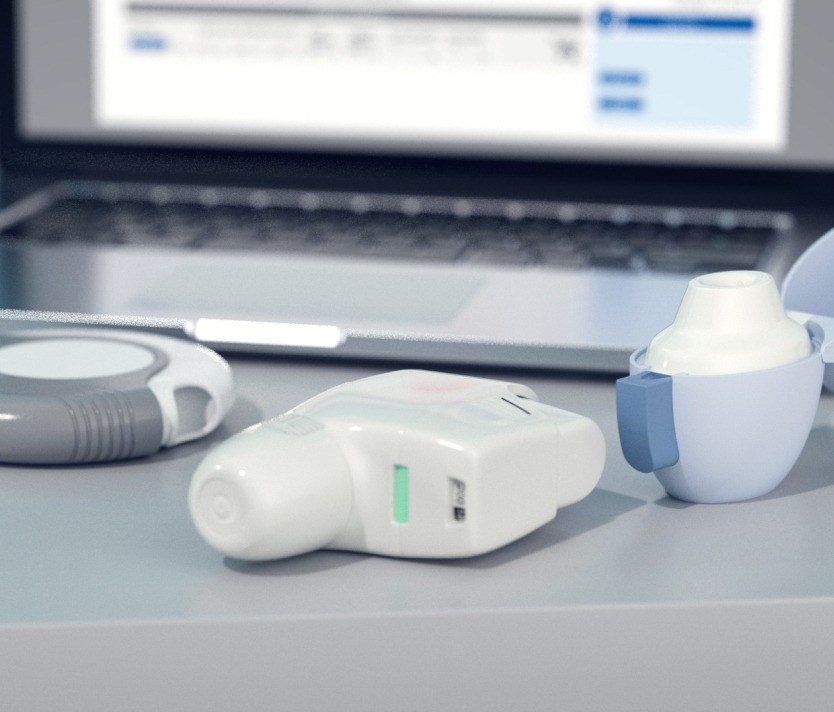 Medizinische Inhalatoren auf einem Tisch vor einem Laptop, Nahaufnahme.