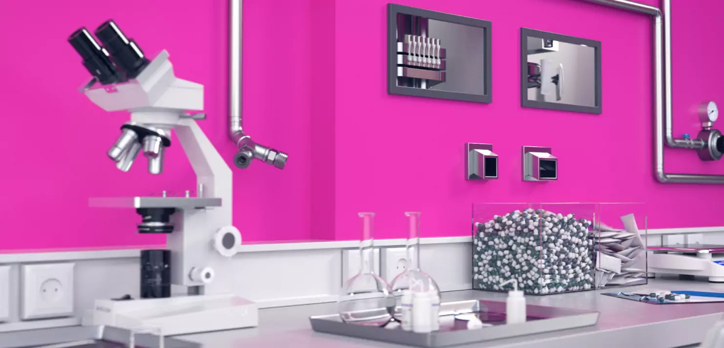 Mikroskop und Laborutensilien vor rosa Wand in modernem Labor. Wissenschaftliche Forschungsumgebung.