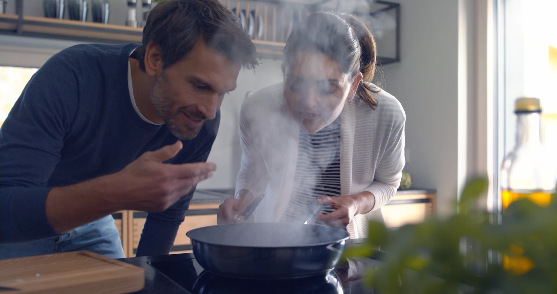 Ein Paar kocht gemeinsam in der Küche, belebt durch leckere Düfte aus der Pfanne.