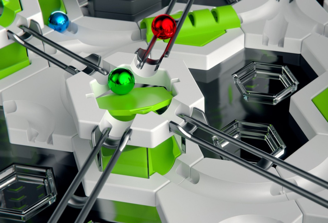 GraviTrax-Pro-h356-5col Futuristisches 3D-Darstellung von farbigen Kugeln und sechseckigen Formen in einem technologischen Muster.